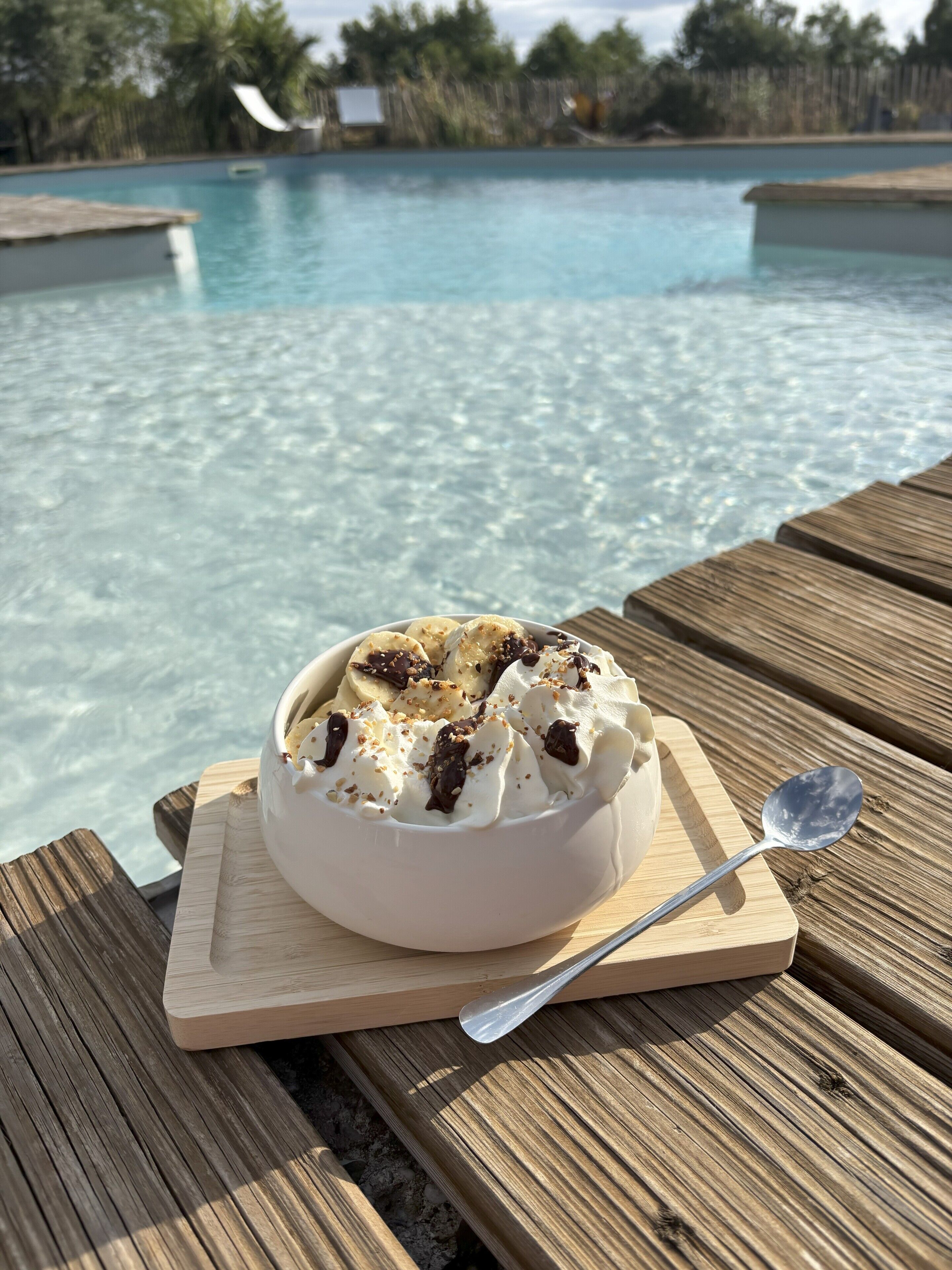 A dessert on a wooden board by a poolside.