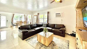 A modern living room with a leather sectional sofa, a glass coffee table, and a ceiling fan. - 2237/U1-Top Pick-Beachfront-Downtown (Fort Lauderdale)