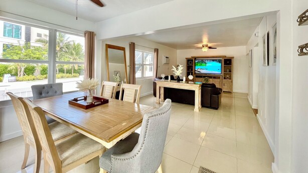A spacious living area with a dining table, chairs, a TV, and a ceiling fan. - 2237/U1-Top Pick-Beachfront-Downtown (Fort Lauderdale)