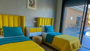 Une chambre d’hôtel avec deux lits, une petite table et une chaise.