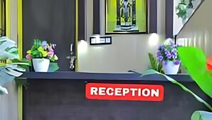 A reception desk with a 'RECEPTION' sign, potted plants, and a view of the outdoors. - hotel shraddha palace (Faizabad)