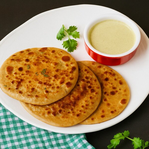 A plate with three flatbreads and a bowl of sauce.