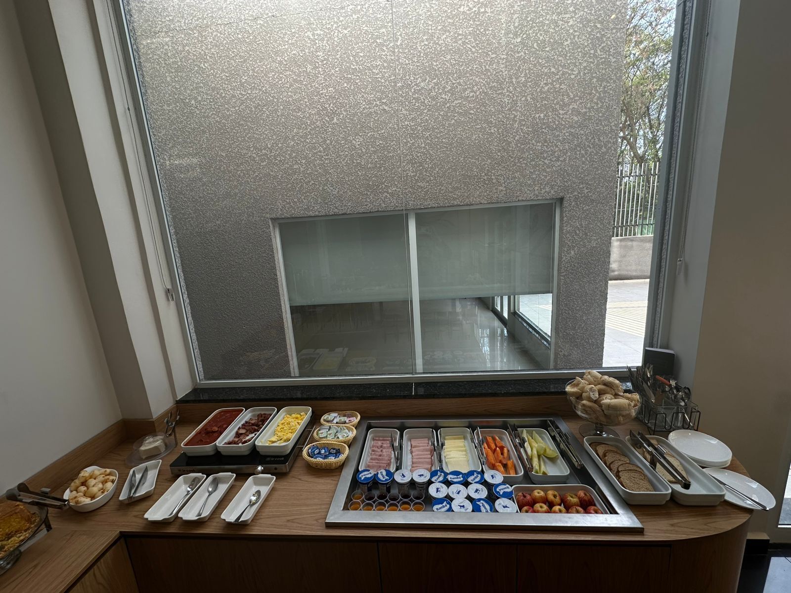 A breakfast buffet with various food items and utensils.