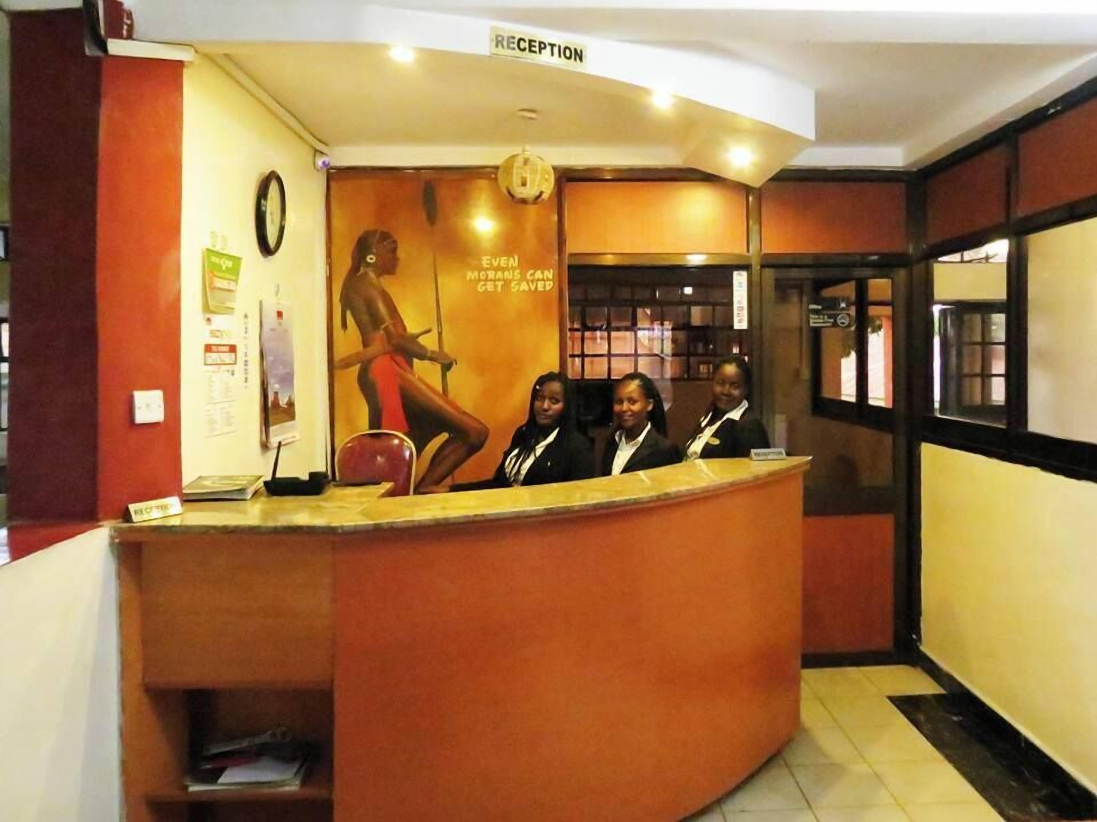 A reception desk with a sign reading "RECEPTION" above it. There is a poster with a message about getting savings.