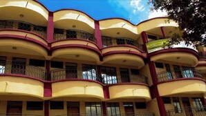 A multi-story building with balconies and a curved facade.