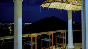 A balcony with wooden chairs and a hanging basket.