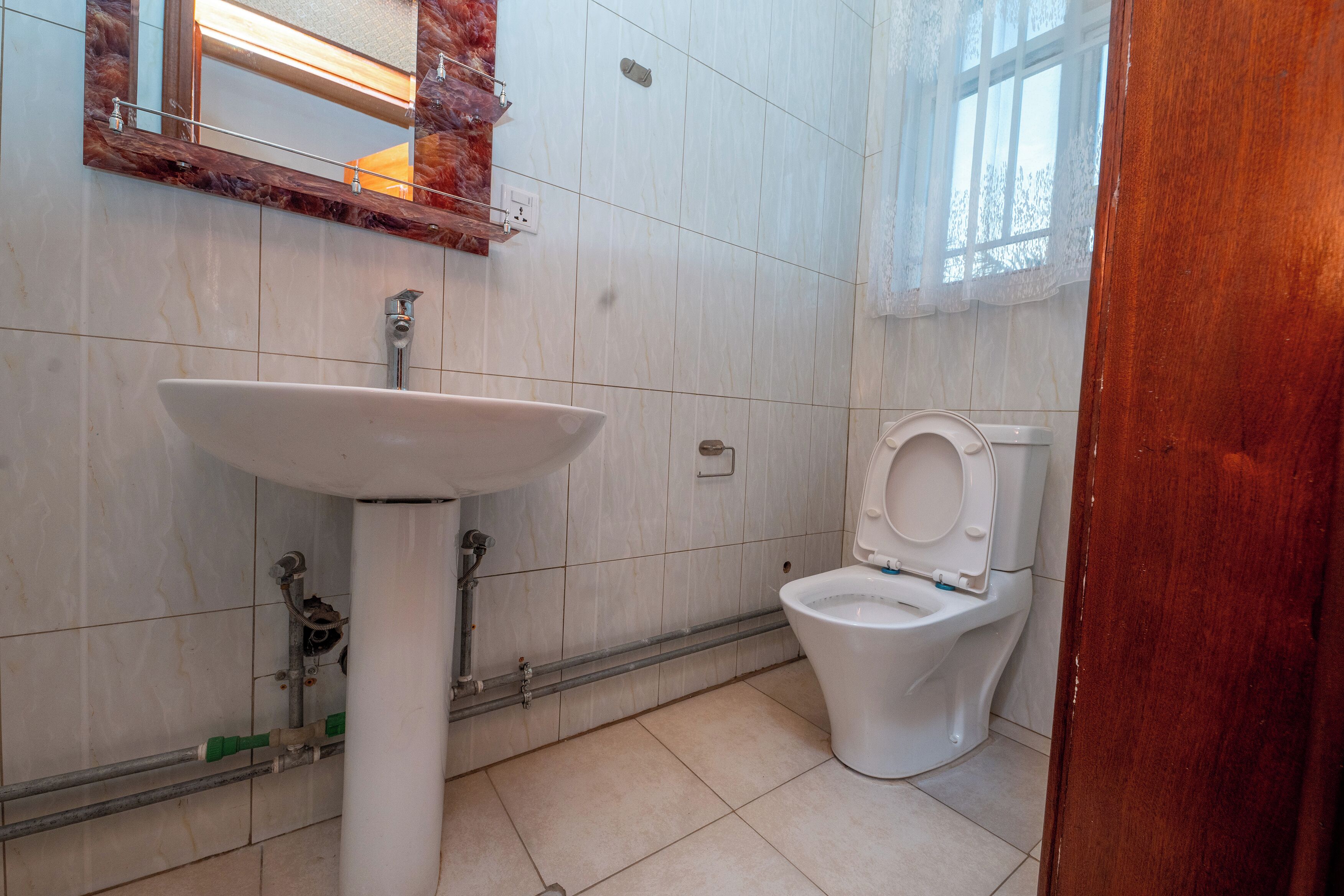 A bathroom with a white sink, a toilet, and a mirror.
