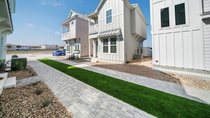Un quartier résidentiel avec des maisons modernes, une allée pavée et une pelouse bien entretenue.