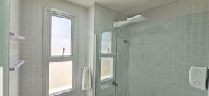 A bathroom with a glass shower enclosure, a window, and a towel hanging on the wall. - COCAZ0107 - Smart Sol do Costa Azul (Salvador)