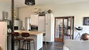 Une cuisine moderne dotée d’un îlot central, de tabourets de bar et d’un coin repas avec un canapé.