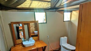 A compact bathroom with a wooden vanity, a sink, a mirror, and a toilet. - Double G Safaris And Camp Mikumi (Dar es Salaam)