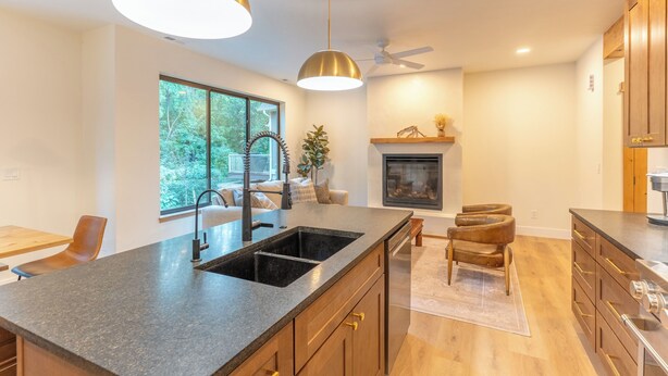 A modern kitchen with a large island, pendant lighting, and a fireplace. - Luxury Mountain-Modern Retreat 3BR near Glacier National Park & Whitefish (Columbia Falls)