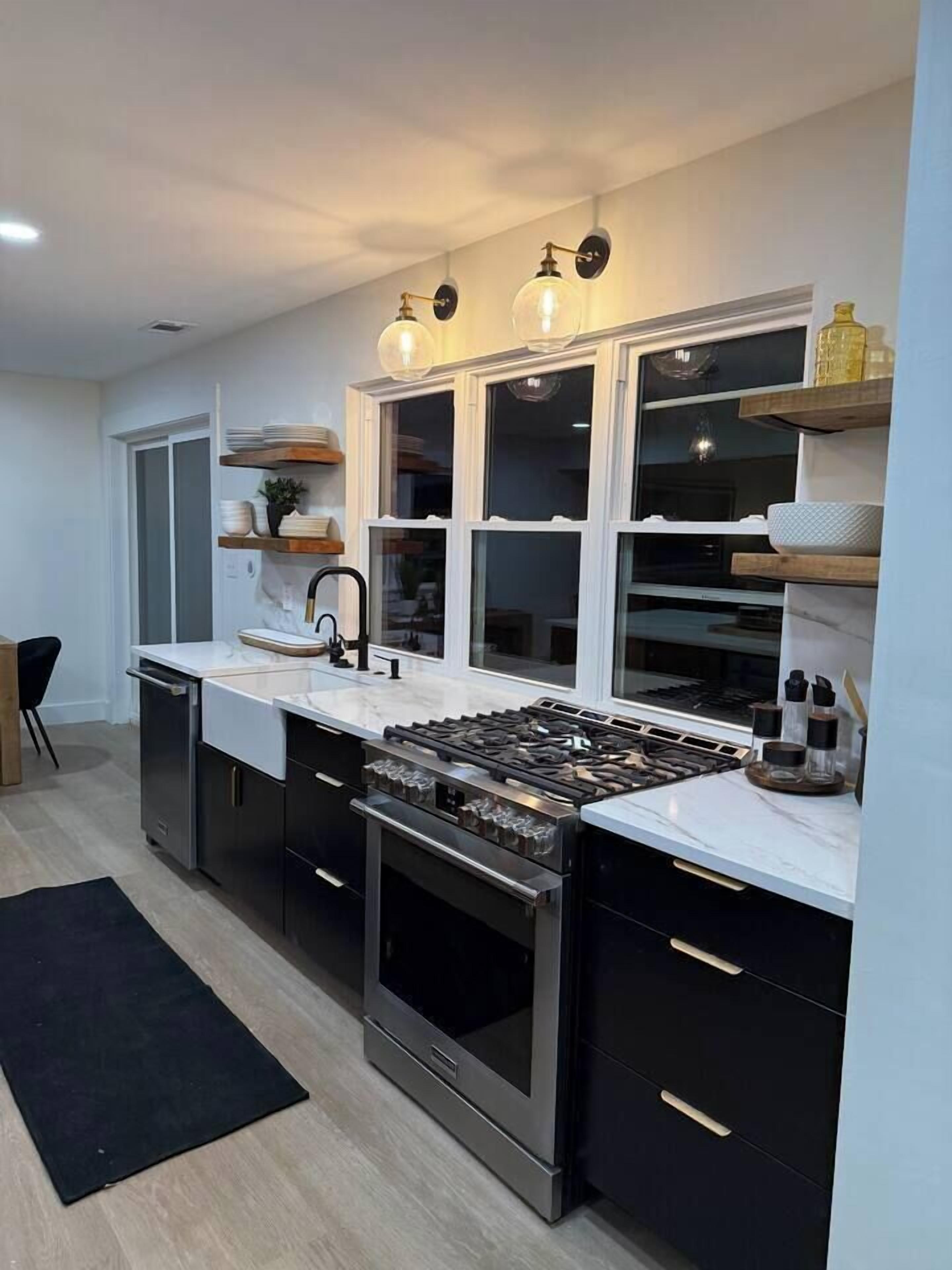 Una cocina moderna con una isla central, electrodomésticos de acero inoxidable y estanterías empotradas.