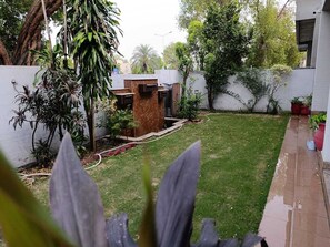 A residential backyard with a lawn, a wooden structure, and various plants. - Spacious 6-bedroom house in DHA Phase 5 Lahore (Lahore)