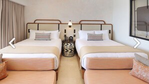 Une chambre d’hôtel avec deux lits, une petite table et un canapé.