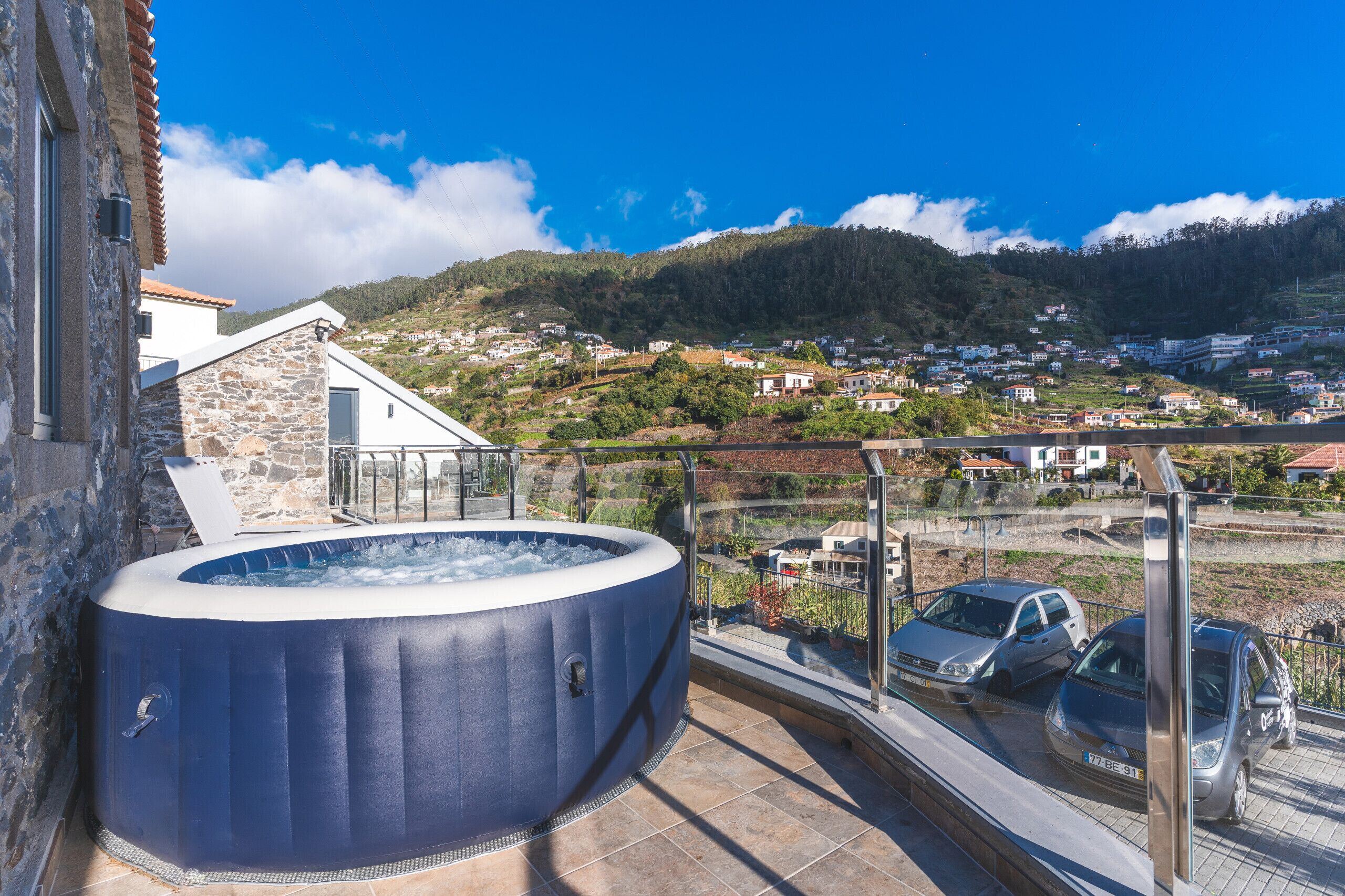 A hot tub on a balcony overlooking a hillside village.
