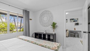 Une chambre moderne avec un grand lit, un bureau et une vue sur l’extérieur.
