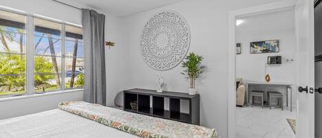 Ein modernes Schlafzimmer mit einem großen Bett, einem Schreibtisch und Blick ins Freie.