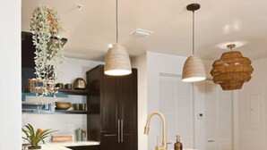 A modern kitchen with a marble countertop, wooden stools, pendant lights, and a potted plant. - Miami Penthouse, Rooftop, Free Parking (Miami)