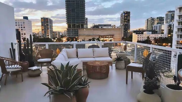 A rooftop terrace with a white sofa, wicker chairs, and potted plants. - Miami Penthouse, Rooftop, Free Parking (Miami)