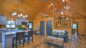 A wooden cabin interior with a kitchen, dining area, and living room. - Willow Falls (Blue Ridge)