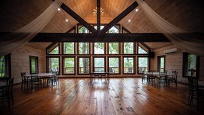 A spacious room with wooden floors and large windows, featuring a high ceiling and natural light. - Willow Falls (Blue Ridge)