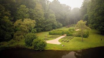A serene park with a pond, benches, and a pathway.