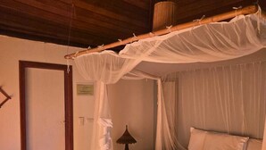 Un lit à baldaquin, une table de chevet et une lampe.