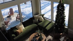 Un salon chaleureux avec un canapé vert, une table basse et un sapin de Noël.