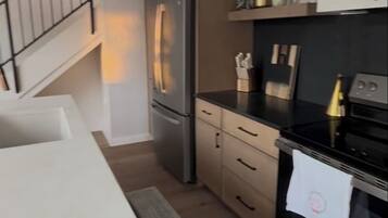 A modern kitchen with a built-in refrigerator, a stove, and a countertop.