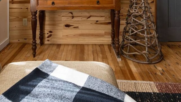 Un mur en bois orné d’un grand miroir, une console en bois et deux lanternes fixées au mur.