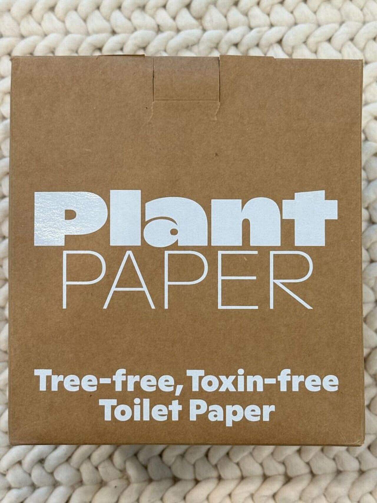 A brown paper bag with the text "Plant PAPER Tree-free, Toxin-free Toilet Paper".