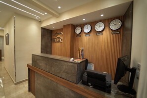 A reception desk with clocks displaying times for London, Cairo, Paris, and New York. - Ra Palace Pyramids View (Giza)