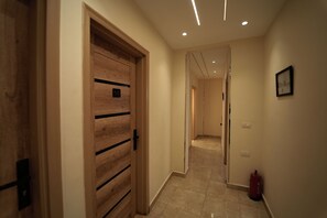 A hallway with a wooden door marked "103", a fire extinguisher, and a framed picture on the wall. - Ra Palace Pyramids View (Giza)