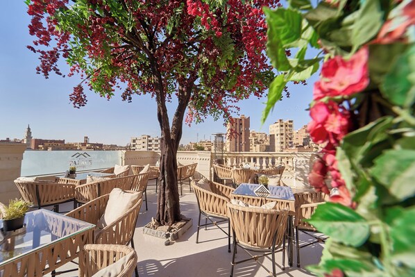 An outdoor seating area with wicker furniture and a view of the cityscape.