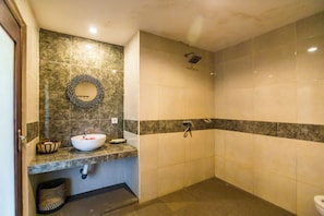 A bathroom with a white sink, a mirror, a towel rack, and a shower area. - Asri Sari Villa Ubud (Ubud)