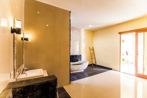 A modern bathroom with a large mirror, a sink, and a bathtub. - Asri Sari Villa Ubud (Ubud)