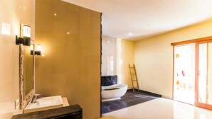 Une salle de bain moderne avec un grand miroir, un lavabo et une baignoire.