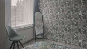 A room with a bed, a chair, a radiator, and a window with sheer curtains. - Elegant 70m² Castle view 6 persons Nature & Quiet Vosges (Senones)