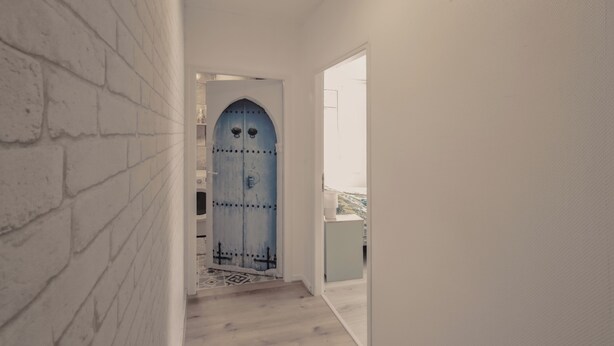 A narrow hallway with a white brick wall on the left and a white door at the end. - Elegant 70m² Castle view 6 persons Nature & Quiet Vosges (Senones)