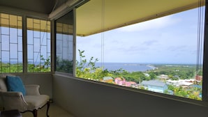 A balcony with a view of the sea and buildings.