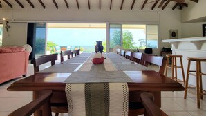A dining area with a long wooden table, chairs, and a ceiling fan.