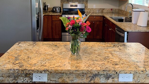 A kitchen with granite countertops, wooden cabinets, stainless steel appliances, and a chandelier. - Fabulous 3-bedroom Hawaiian home. (Waimea)