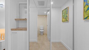 Ein modernes Badezimmer mit Toilette, einem Waschbecken mit Granitplatte und einer Duschkabine.