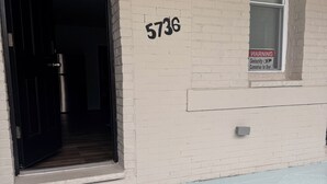A building entrance with a black door, a number '5736' on the wall, and a warning sign about security cameras. - Amazing 2-bedroom apartment with AC in Philadelphia (Philadelphia)