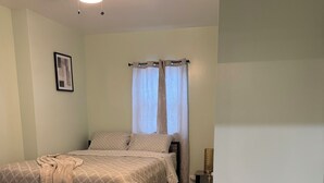 A bedroom with a bed, a ceiling fan, a window with curtains, and a white appliance. - Amazing 2-bedroom apartment with AC in Philadelphia (Philadelphia)