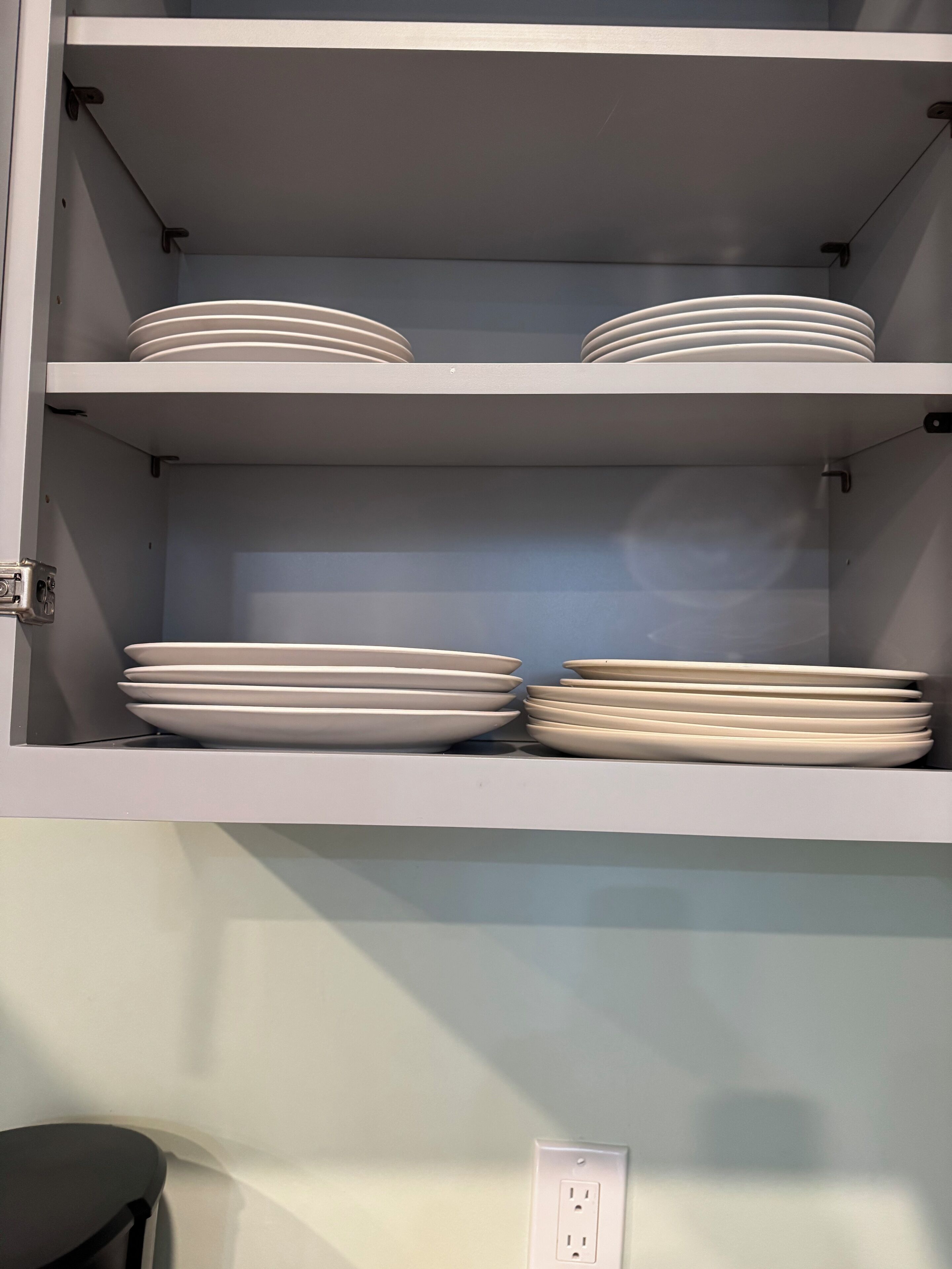 Un meuble de cuisine doté de plusieurs étagères, dont certaines contiennent des piles d’assiettes.