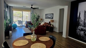 Een eetgedeelte met een ronde tafel, zwarte stoelen en geweven placemats.