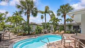 A swimming pool with a 3ft 4in depth, surrounded by palm trees and outdoor furniture. - Coconut cabana, freshly renovated unit September 2025 heated pools (Clearwater)