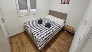 Une chambre à coucher avec un lit, une fenêtre, une table de chevet et un tableau au mur.